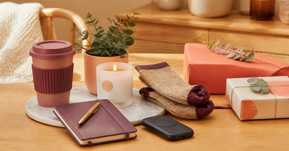 Useful affordable gifts including a reusable cup, notebook, socks and small plant